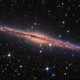 Illustration for article titled A galaxy cuts through space like a scar made of light